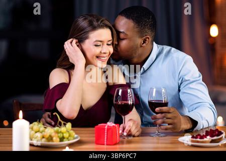 Ritratto di affettuosa coppia Interrazziale con Data Romantica in Ristorante Foto Stock