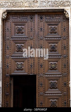 Primo piano di una porta in legno scolpita nella Cattedrale di Firenze, Toscana, Italia Foto Stock