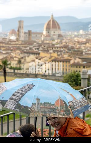 Firenze, Italia - 10 maggio 2025: Turista con un ombrello ricordo con i monumenti italiani, con lo skyline della città e il Duomo sullo sfondo Foto Stock