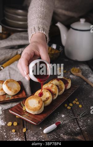Cibo, torte di formaggio cottage versate con marmellata di bacche Foto Stock