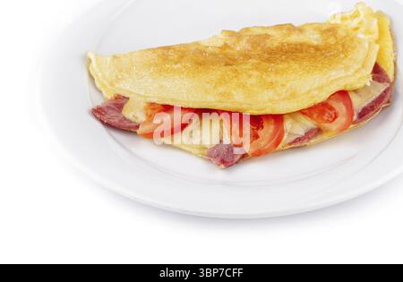 Cibo, deliziose omelette piegate ripiene di formaggio, prosciutto e pomodori, servite su un piatto bianco, isolato su sfondo bianco Foto Stock