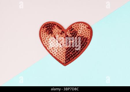 Rosso sequine cuore su sfondo blu e rosa. Layout minimo creativo con spazio per la copia di San Valentino Foto Stock