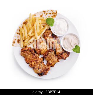 Il piatto comprende pezzi di pollo alla griglia accompagnati da patatine fritte dorate e due tipi di salse. Foglie di menta guarnire il piatto, presentando un invitante Foto Stock