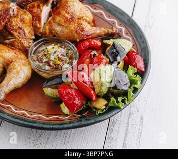 Cibo, delizioso pollo arrosto servito su un piatto con verdure alla griglia e salsa Foto Stock