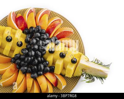 Cibo, variopinta varietà di frutta fresca, tra cui uva, mango e papaya su un piatto rotondo di vimini Foto Stock