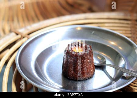Deliziosi anele appena sfornati, rum e vaniglia. Pasticceria francese con crosta caramellata su piatto d'argento. Una specialità della regione di Bordeaux Foto Stock
