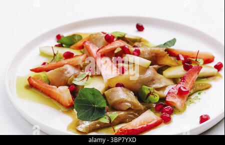 Cibo, pesce con fragole, pere e melograni in salsa Foto Stock