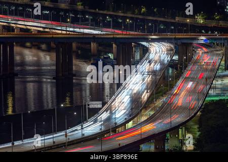 Traffico notturno dell'autostrada con sentieri leggeri - trasporto urbano e paesaggio urbano Foto Stock