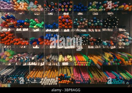 Penne multicolore con punta in feltro e matite in legno grafite su un ripiano in un punto vendita. Foto Stock