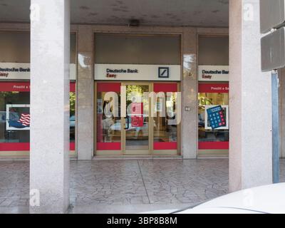 Cremona, Italia 28 giugno 2025 porte e finestre di vetro della filiale Deutsche Bank Easy di Cremona, Lombardia, che riflettono la vivace scena Street Foto Stock