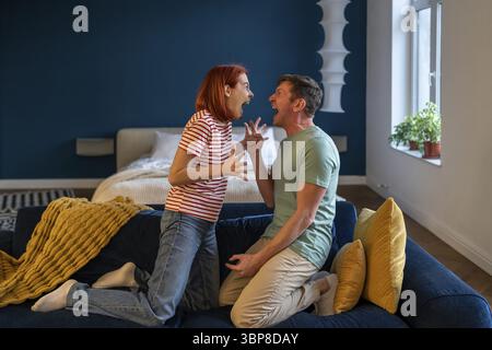 Uomo e donna litigano, urlano, litigano. Marito e moglie, coppia sposata ad alta voce, emotivamente gridano l'un l'altro durante una violenta lite, cercando di fare pubbliche relazioni Foto Stock