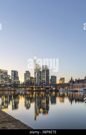 Vista sul fiume meno con uno skyline moderno illuminato sullo sfondo la sera, al tramonto. Splendida vista della città e dei suoi dintorni Foto Stock