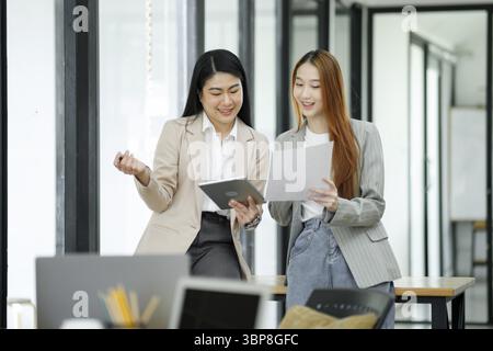 Le donne lavoratrici discutono di lavoro e pianificano nuovi piani aziendali scambiando idee con i colleghi Foto Stock