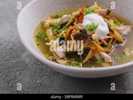 Cibo, abbondante zuppa azteca con strisce di tortilla, avocado e formaggio, guarnita con panna acida Foto Stock