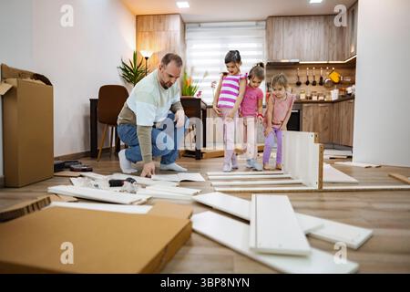 Tempo di legame con la famiglia durante un progetto di casa nell'accogliente cucina Foto Stock