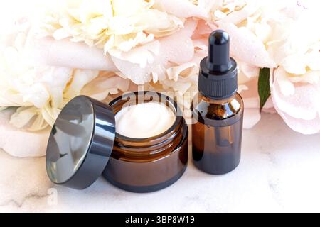 Siero facciale anti-invecchiamento in collagene in flacone di vetro scuro e crema viso su sfondo bianco con spazio di copia. Concetto di bellezza cosmetica biologica naturale. MOC Foto Stock