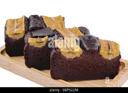 Cibo, pane alla banana al cioccolato appena sfornato con condimenti alla banana su un tavolo da portata in legno, isolato su bianco Foto Stock