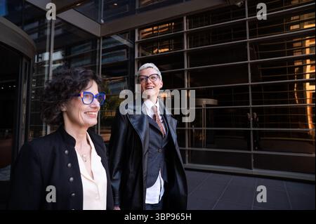 Due donne d'affari sorridono e camminano fuori dall'edificio degli uffici Foto Stock