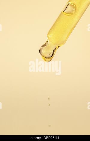 Pipettare con siero, gel, olio o altro prodotto cosmetico con gocce cadenti. Primo piano macro Foto Stock