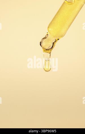 Pipettare con siero, gel, olio o altro prodotto cosmetico con gocce cadenti. Primo piano macro Foto Stock