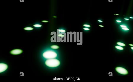 Puntini verdi brillanti astratti che fluttuano su uno sfondo scuro. Rendering 3D. Foto Stock