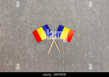 Due mini bandiere Romania su Toothpick su superficie grigia Foto Stock