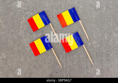 Quattro prese con bandiera rumena visualizzate su una superficie in cemento Foto Stock
