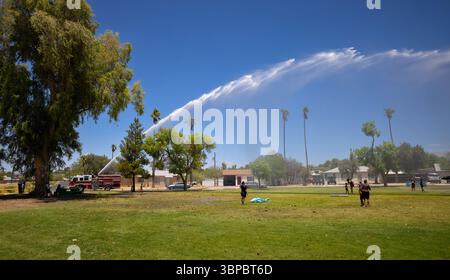 Il camion dei pompieri spruzza acqua sui bambini per divertirsi in estate al Parkview Park di Tucson, Arizona, una pausa fresca sotto il sole del deserto. Foto Stock
