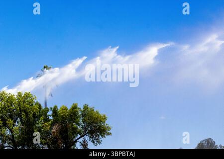 Il camion dei pompieri spruzza acqua sui bambini per divertirsi in estate al Parkview Park di Tucson, Arizona, una pausa fresca sotto il sole del deserto. Foto Stock