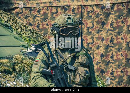 Soldato delle forze speciali dell'esercito lituano con equipaggiamento militare, maschera protettiva, occhiali e maschera, con mitragliatrice, nascondendo il suo volto Foto Stock