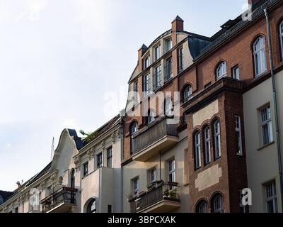 Facciata di un edificio residenziale nello stile di un vecchio edificio industriale. Ex fabbrica convertita in una casa di appartamenti in una città. Pietre di mattoni rossi. Foto Stock