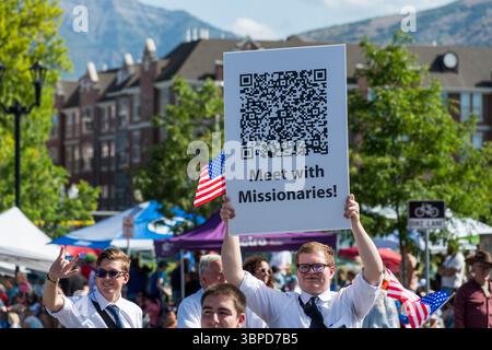 Provo, UT – 4 luglio 2025: I membri della Chiesa di Gesù Cristo dei Santi degli ultimi giorni marciano con bandiere statunitensi e segni di fede nella Parata del Festival della libertà. Foto Stock