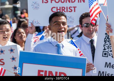 Provo, UT – 4 luglio 2025: I membri della Chiesa di Gesù Cristo dei Santi degli ultimi giorni marciano con bandiere statunitensi e segni di fede nella Parata del Festival della libertà. Foto Stock