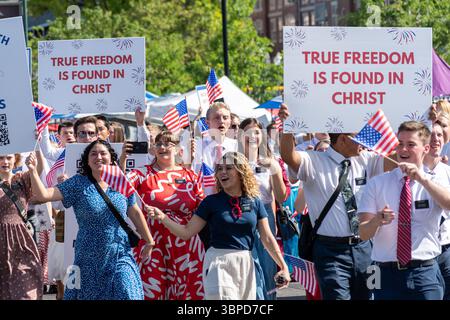 Provo, UT – 4 luglio 2025: I membri della Chiesa di Gesù Cristo dei Santi degli ultimi giorni marciano con bandiere statunitensi e segni di fede nella Parata del Festival della libertà. Foto Stock