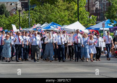Provo, UT – 4 luglio 2025: I membri della Chiesa di Gesù Cristo dei Santi degli ultimi giorni marciano con bandiere statunitensi e segni di fede nella Parata del Festival della libertà. Foto Stock