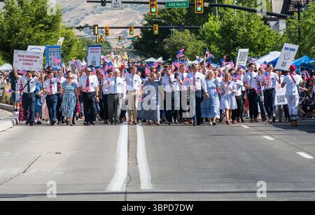 Provo, UT – 4 luglio 2025: I membri della Chiesa di Gesù Cristo dei Santi degli ultimi giorni marciano con bandiere statunitensi e segni di fede nella Parata del Festival della libertà. Foto Stock