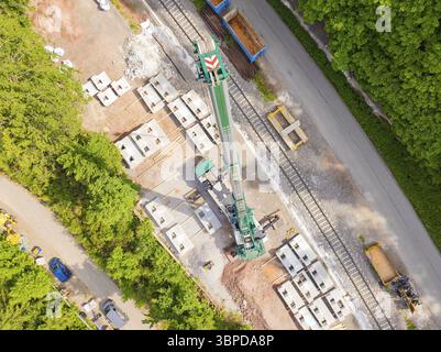 Una grande gru in un cantiere vicino a rotaie e materiali da costruzione, costruzione della ferrovia Hermann Hesse, Calw, Germania, Europa Foto Stock