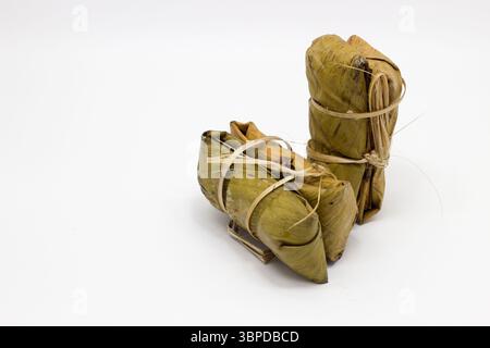 Khao Tom Mat (riso appiccicoso tailandese con banana): Un tradizionale dessert tailandese a base di riso appiccicoso stagionato e latte di cocco, ripieno di banana e beaut Foto Stock