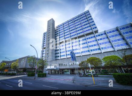 Moderno ed alto edificio per uffici a Berlino con facciata in vetro a parete tenda e nucleo in cemento, che presenta un'architettura aziendale contemporanea. Foto Stock
