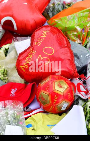 Tributi floreali, sciarpe, palloncini, messaggi di condoglianze ecc. sono collocati fuori dal Liverpool Football Club in memoria di Diogo Jota ucciso in RTA. Foto Stock