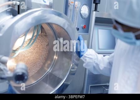 Linea di produzione automatizzata di tablet in un moderno impianto farmaceutico con processi di confezionamento e controllo della qualità avanzati Foto Stock