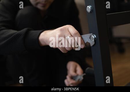 Lo specialista della riparazione di mobili assembla un nuovo guardaroba a casa, aiutandoti a rinfrescare lo spazio senza problemi. Foto Stock