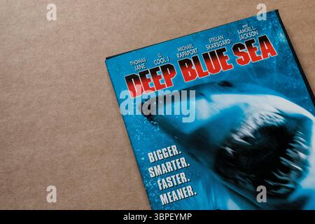 Copertina DVD Deep Blue Sea con squalo, attori principali e parole "Bigger. Più intelligente. Più veloce. Più cattivo." isolato su fondo di cartone. Foto Stock