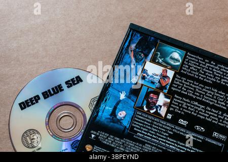 Retrocopertina con immagini di film e DVD di Deep Blue Sea isolati su un semplice sfondo di cartone. Foto Stock