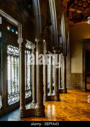 Le colonne in marmo lucido si riflettono sul pavimento in parquet della grande sala del Palau Güell, un capolavoro in stile Art Nouveau di Gaudí a Barcellona, Spagna. Foto Stock