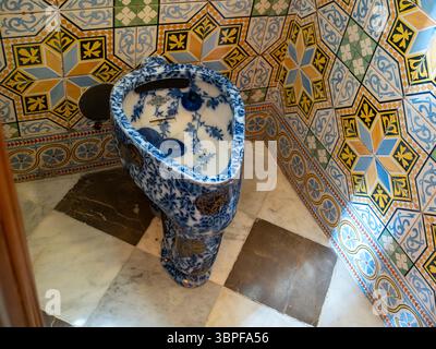Un bagno storico ornato con motivi floreali blu e bianchi e piastrelle colorate all'interno del Palau Güell di Antoni Gaudí, Barcellona, Spagna. Foto Stock