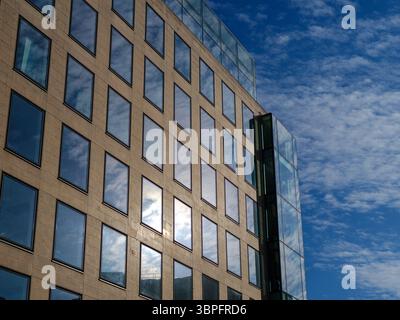 Regno Unito, Londra, 09 luglio 2025. Moderno edificio di uffici con finestre a griglia che riflettono il cielo blu e le nuvole in una luminosa giornata estiva nel centro di lo Foto Stock