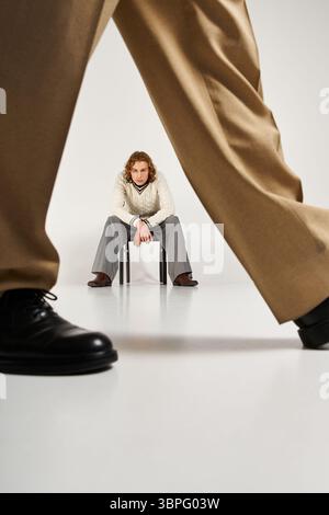 Due giovani uomini alla moda mettono in mostra il loro stile unico e la loro energia giocosa in uno studio chic. Foto Stock
