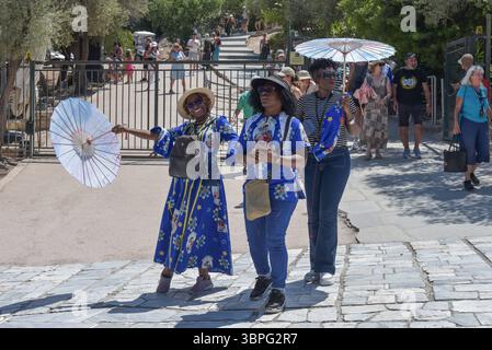 L'Acropoli di Atene è chiusa mentre le cime delle ondate di calore in Grecia i turisti che trasportano ombrelli per proteggersi lasciano l'Acropoli di Atene, chiusa tra le 13:00 e le 17:00 per proteggere i visitatori e i lavoratori dal caldo intenso come la seconda ondata di caldo dei picchi stagionali in Grecia. Atene Grecia Copyright: XNicolasxKoutsokostasxNicolasxKoutsokostasx DSC 202507080748 Foto Stock