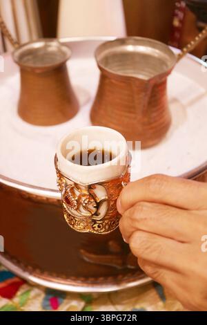 Primo piano del caffè turco con le caldaie chiamate Cezve poste sulla sabbia calda sullo sfondo Foto Stock